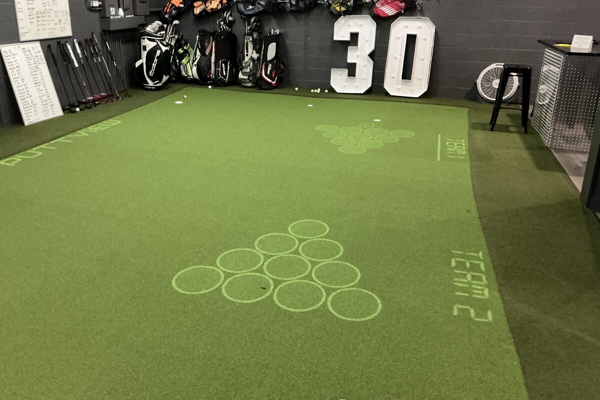 The putting green with a target game projected onto the surface and the PuttView name projected along the near edge.
